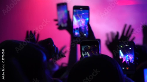 Slow Motion Video. Hands of man holding smartphone in air to film video of concert atmosphere vertical Stock Video