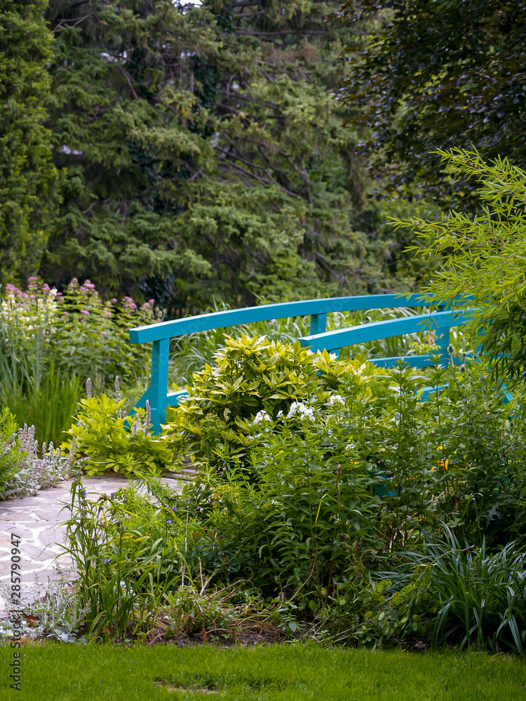 Vienna, Austria-Juli 15,2004:.turquoise wooden bridge in a lush garden in Vienna, called the Monet gar Vienna, Austria-Juli 15,2004:.turquoise wooden bridge in a lush garden in Vienna, called the Monet gar