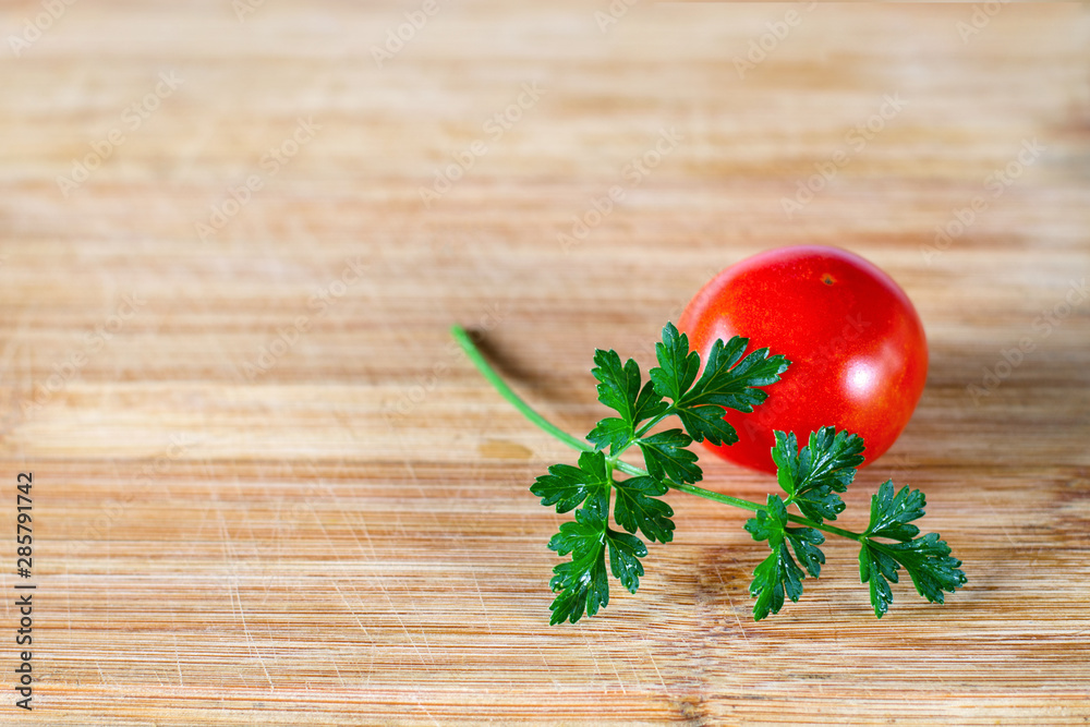 Tomato behind a sprig of parsley Tomato behind a sprig of parsley
