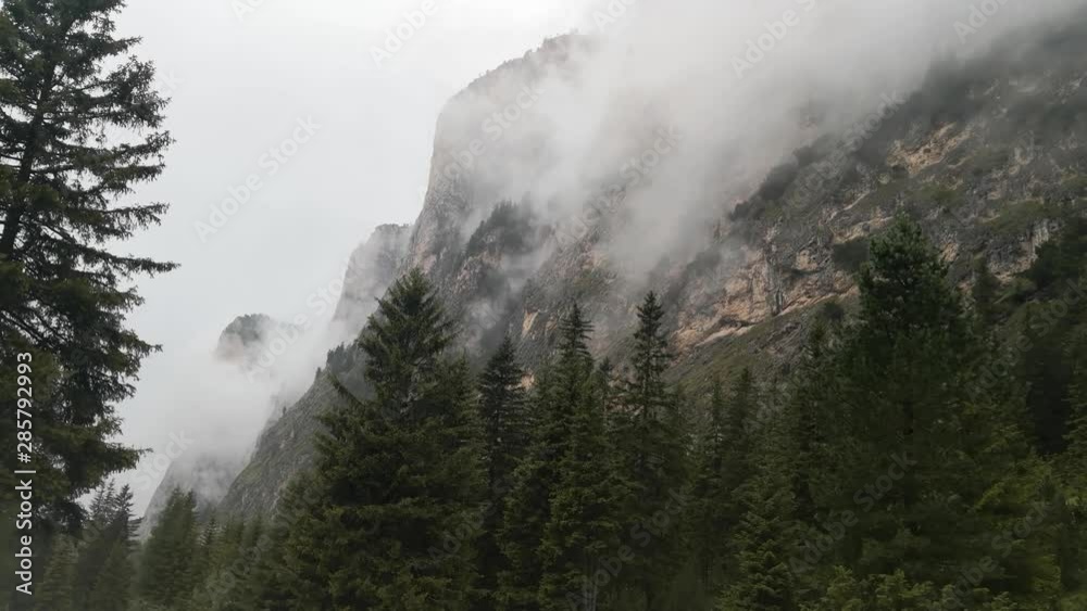 Mountains engulfed in fog and clouds on a rainy day in Vallunga valley, Selva, South Tyrol, Italy.
