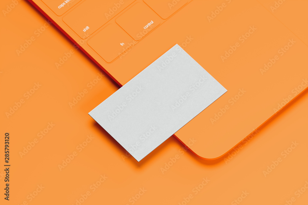 Orange laptop with white blank business card on orange background. 3d rendering. Cozy working place. Minimalism Orange laptop with white blank business card on orange background. 3d rendering. Cozy working place. Minimalism