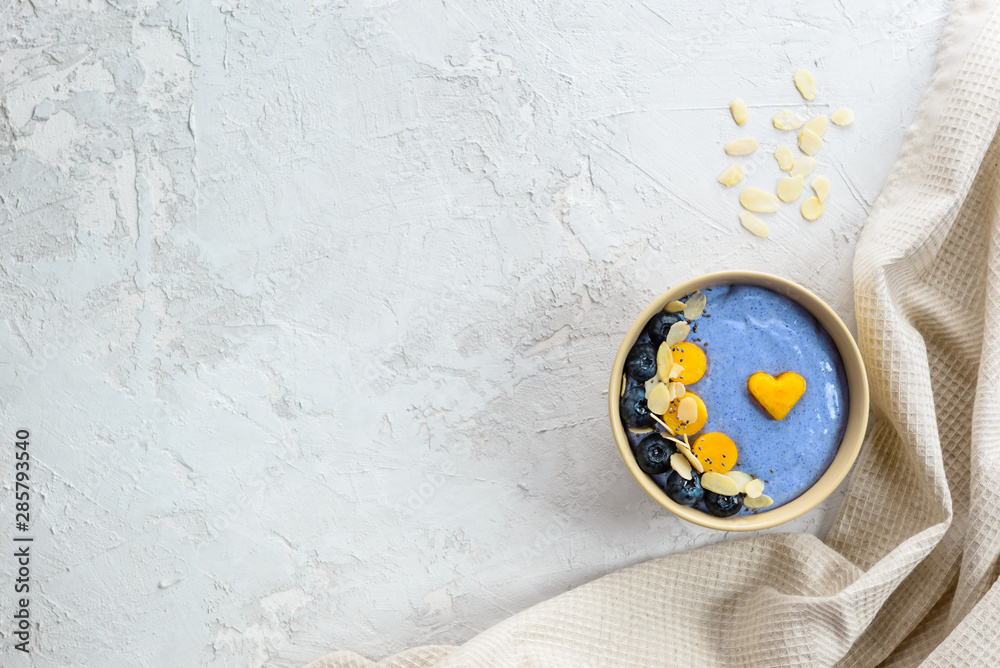 Blue matcha smoothies with berries and fruits in a bowl on a gray. Blue matcha smoothies with berries and fruits in a bowl on a gray.