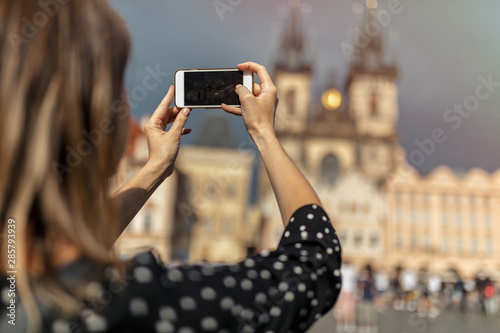 woman with mobile phone take a shot of old town in Prague