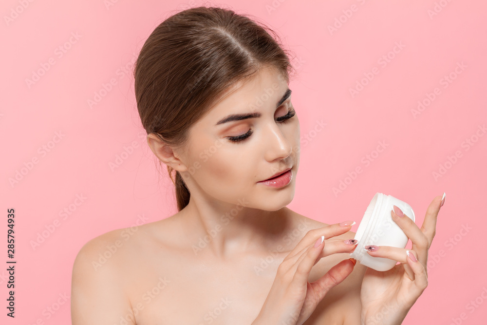 Beautiful model applyes moisturizing cream to skin holding white tube of a hyaluronic cream. Beautiful model applyes moisturizing cream to skin holding white tube of a hyaluronic cream.