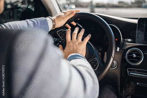 Angry driver is honking with a steering wheel. Concept of road aggression. Traffic jam. © ianachyrva