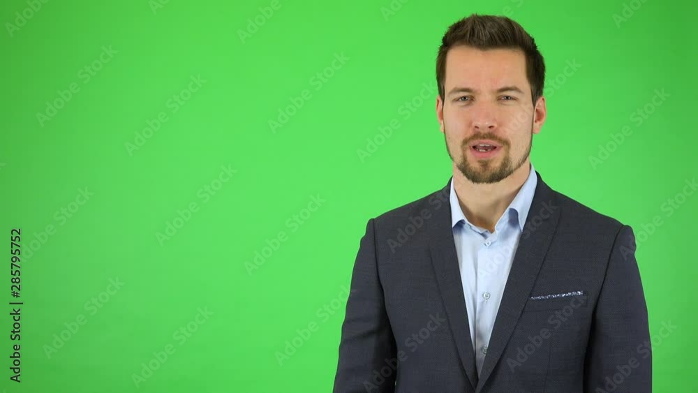 A young handsome businessman talks to the camera with a smile - green screen studio A young handsome businessman talks to the camera with a smile - green screen studio