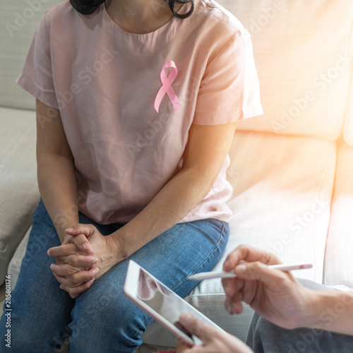 Breast cancer pink awareness ribbon on woman patient consulting with doctor who diagnostic examining on obstetric - gynaecological female illness in medical clinic or hospital