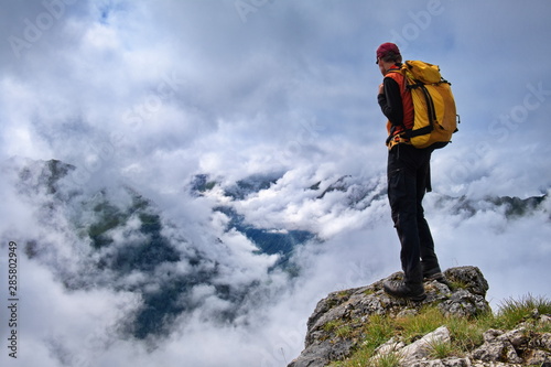 Mann, Bergsteiger, Wanderer steht auf Fels oder Gipfel