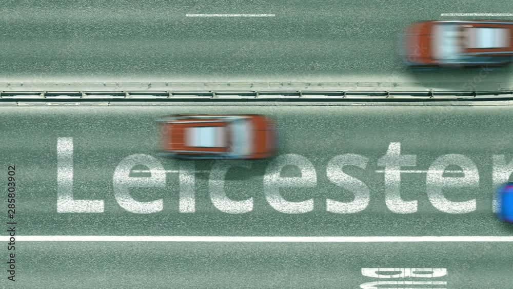 Aerial down view of the motorway with cars revealing Leicester caption. Car travel to the United Kingdom intro clip Aerial down view of the motorway with cars revealing Leicester caption. Car travel to the United Kingdom intro clip
