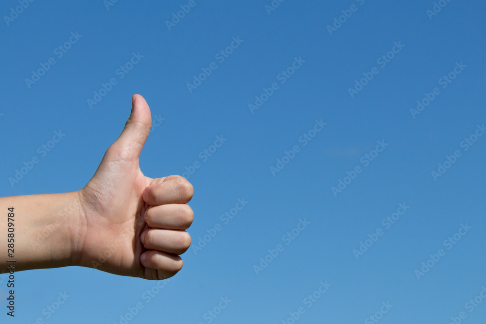 hand with thumb up on blue sky hand with thumb up on blue sky