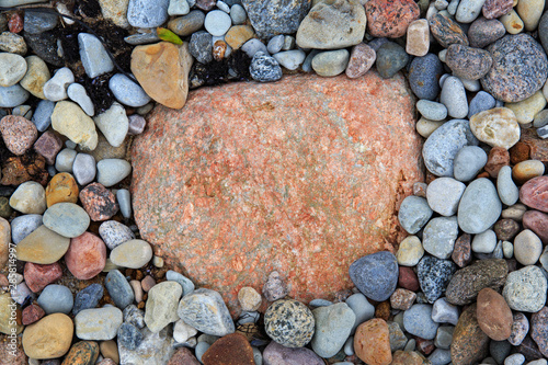 Large stone of red and pink color, surrounded by smaller stones.