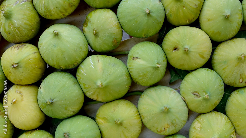 Closeup of unripe green figs in wooden crate Closeup of unripe green figs in wooden crate