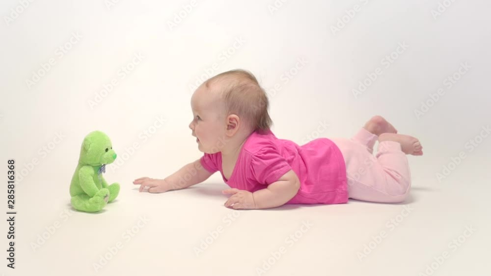 Cute baby girl playing with soft toy on white background Cute baby girl playing with soft toy on white background