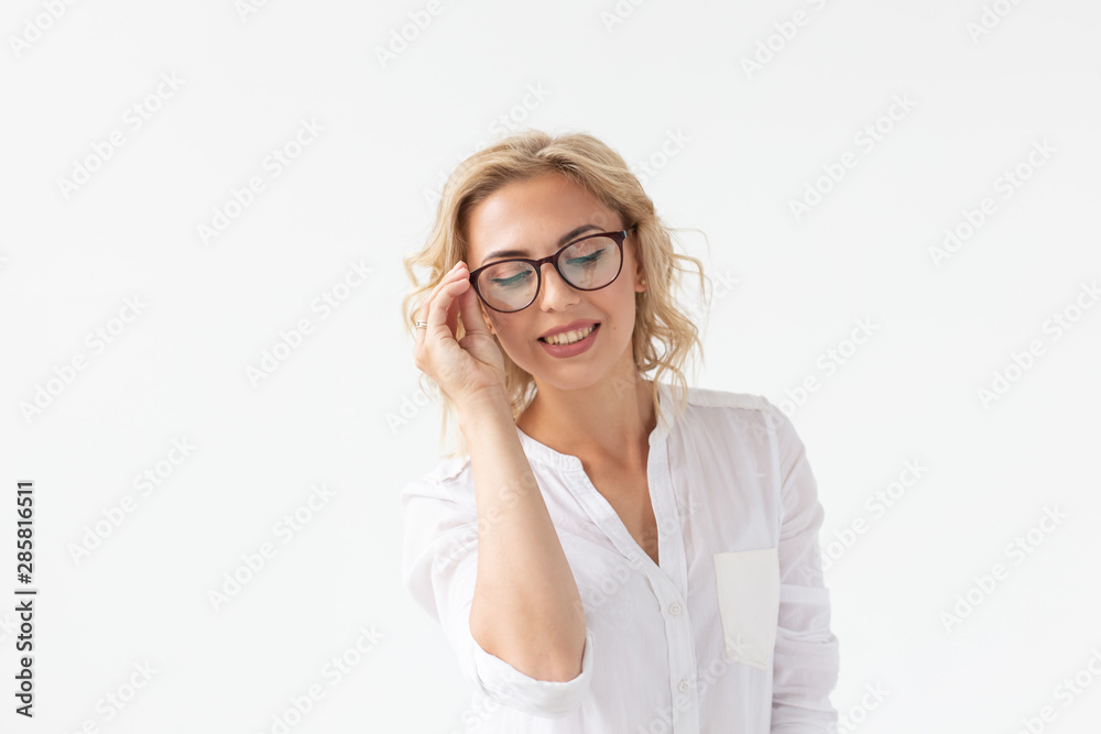 Portrait of concentrated beautiful woman with bad vision touching glasses isolated on white background