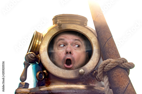 Portrait of man in old diving suit and helmet, isolated on white background. Funny diver in retro equipment in amazement looks around.