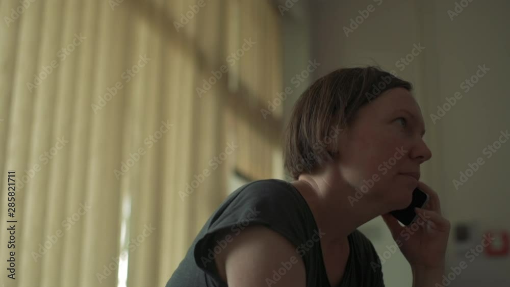 Woman during mobile phone conversation in hotel lobby, handheld footage Woman during mobile phone conversation in hotel lobby, handheld footage