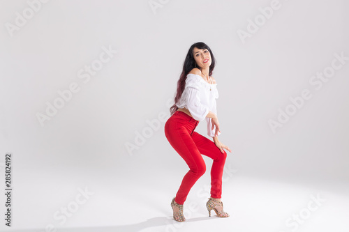 Latin dance, contemporary dance, bachata solo and cha-cha-cha concept - portrait of a young woman salsa dancer in a dance pose on white background with copy space © satura_