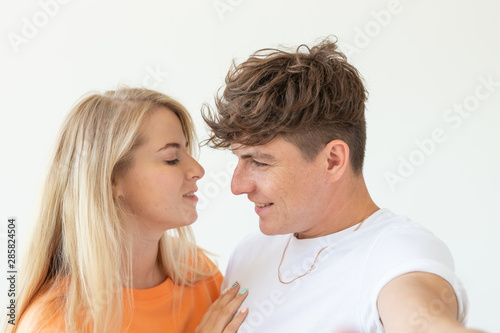 Portrait of a cute positive cheerful young couple of students taking selfie on a smartphone or camera. The concept of a passionate young couple in love with students.