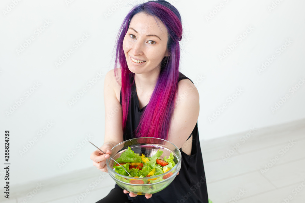 Young fitness girl holding vegetable salad. Concept of sports lifestyle and proper nutrition. Young fitness girl holding vegetable salad. Concept of sports lifestyle and proper nutrition.