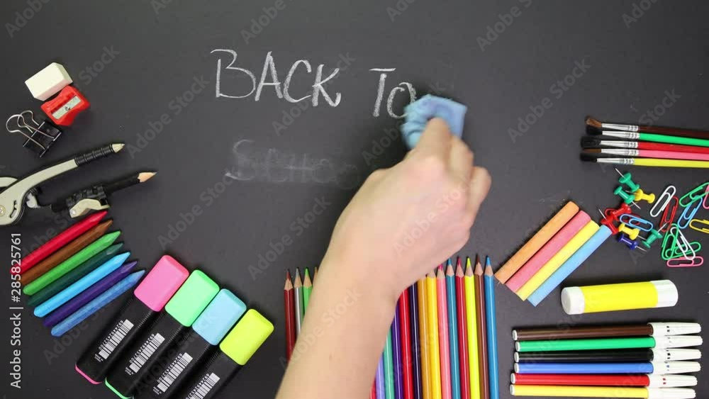 Beautiful women hand reveling back to school words written on black board with white chalk. Education, back to school concept with copy space.