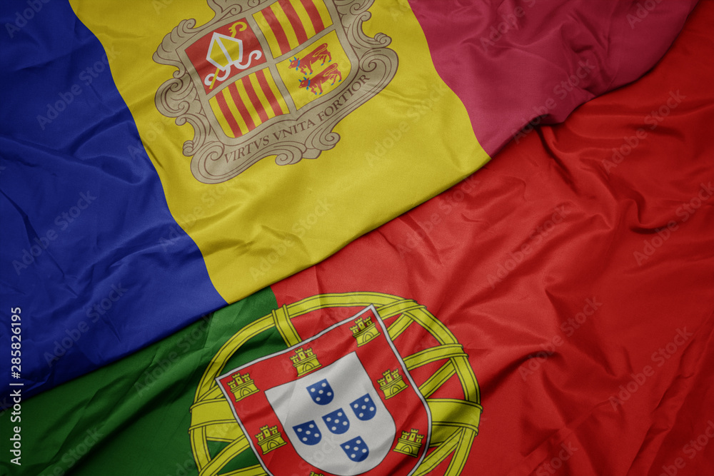 waving colorful flag of portugal and national flag of andorra.