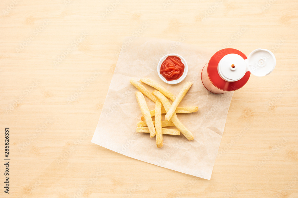 Fototapeta premium Top view of french fried with tomato sauce ( ketchup ) on wood table background.Fast food and unhealthy eating concepts