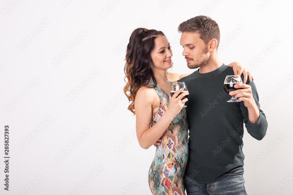 Man and woman are holding glasses of dark beer on white background with copy space. Oktoberfest concept. Man and woman are holding glasses of dark beer on white background with copy space. Oktoberfest concept.