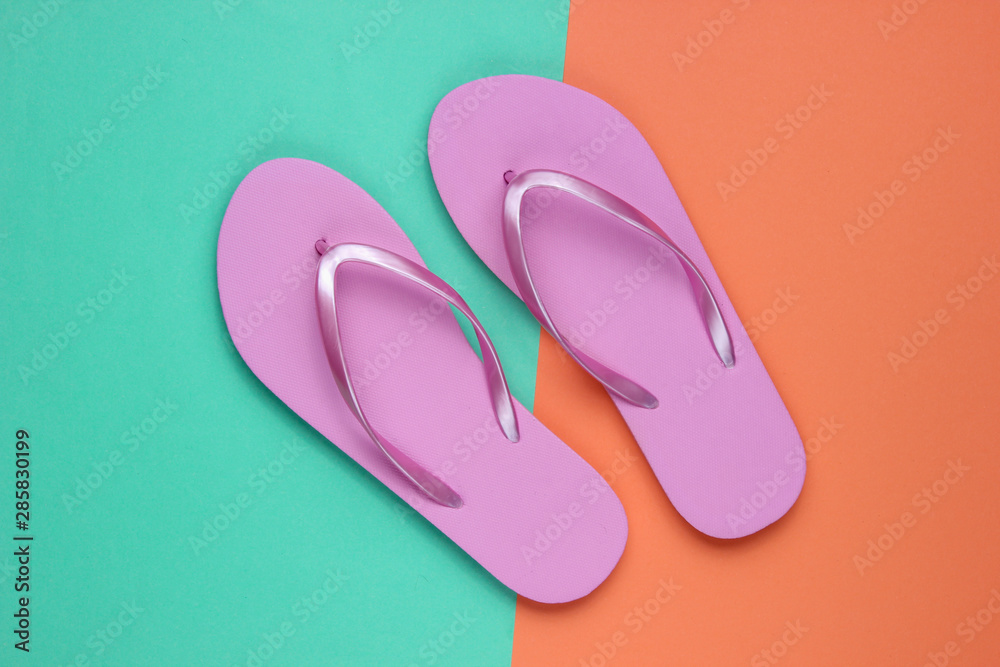 Trendy beach pink flip flops on coral blue paper background. Top view Trendy beach pink flip flops on coral blue paper background. Top view