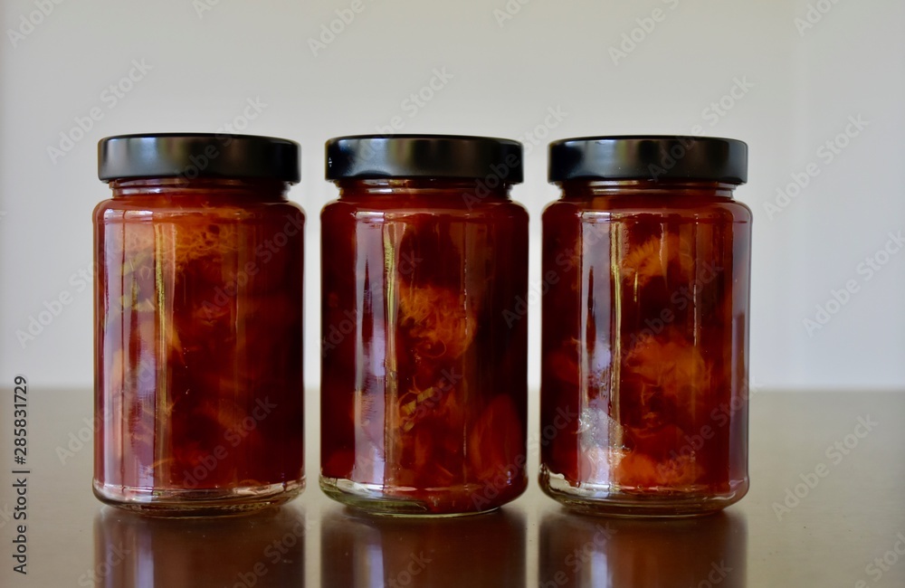 three glass jars in a row with delicious coarse home made plum jam three glass jars in a row with delicious coarse home made plum jam