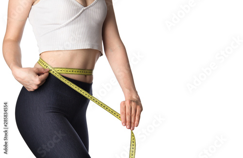 Woman measuring her body. Slim woman measuring her waist isolated on white background. Healthy nutrition and weight losing concept. Body fat reduction. Copy space.