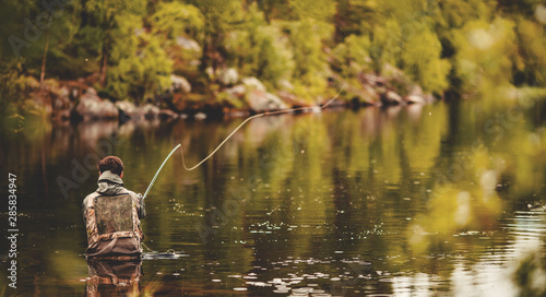 Foto Fisherman using rod fly fishing in river morning sunrise banner