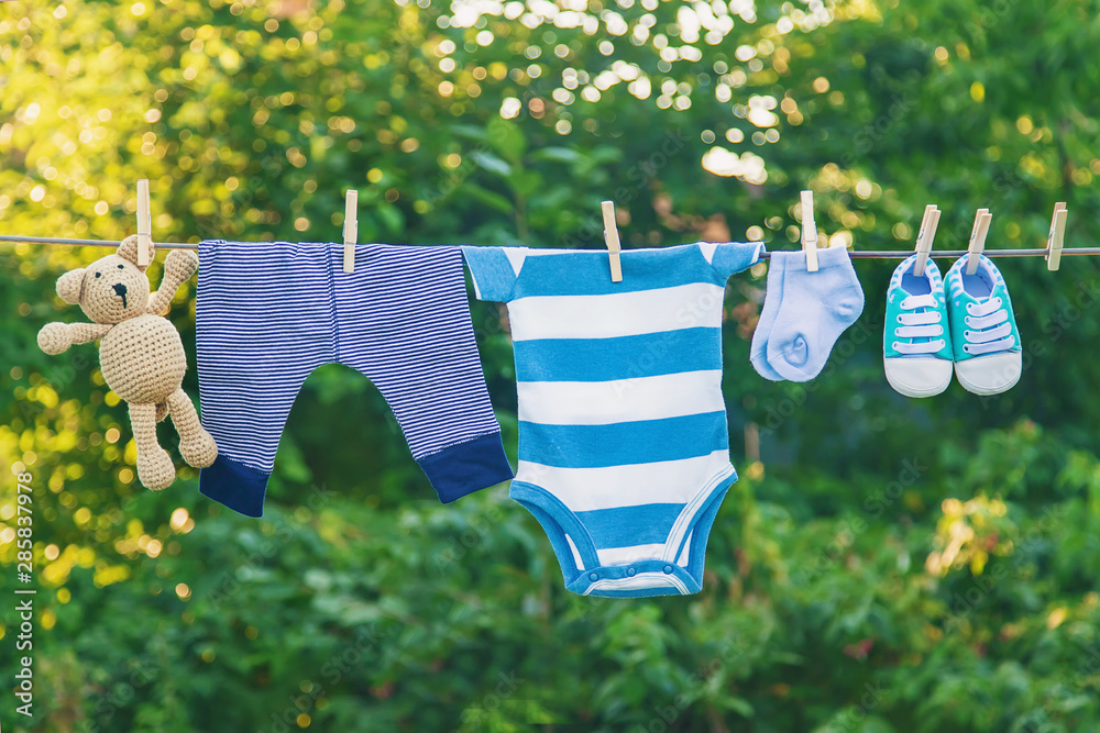 washing baby clothes. Linen dries in the fresh air. Selective focus. - obrazy, fototapety, plakaty 