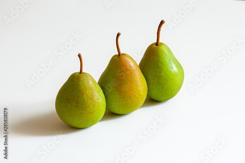 3 ripe green pears on a white background one after another, studio shooting