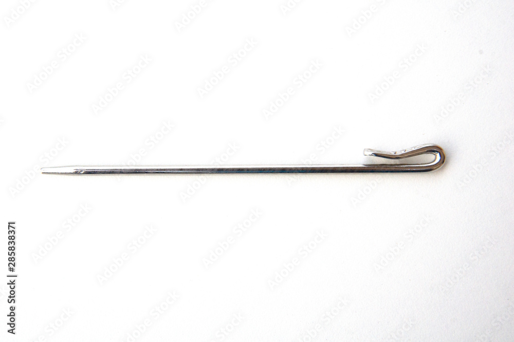Needle like metal object isolated on white background. This can be used for sewing as well as tidying hair for Sikh boys and men. Needle like metal object isolated on white background. This can be used for sewing as well as tidying hair for Sikh boys and men.