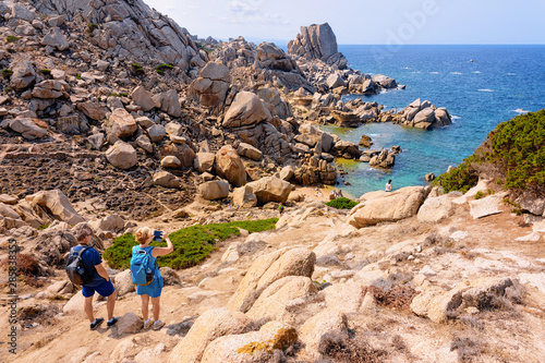 Couple looking at rocks on Capo Testa Sardinia photo