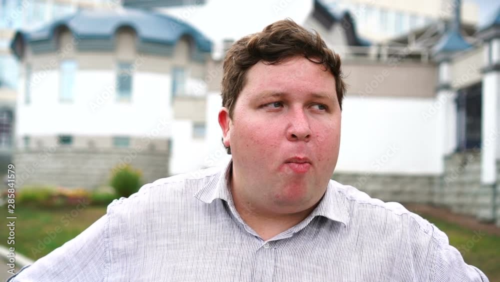 Handsome fat young man portrait who chewing bubble gum. Emotional men looking at camera Handsome fat young man portrait who chewing bubble gum. Emotional men looking at camera