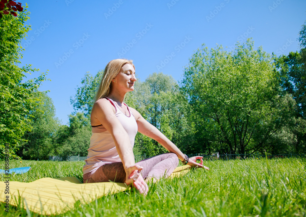 Young woman practicing yoga on nature in park, relax in nature Young woman practicing yoga on nature in park, relax in nature