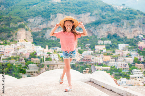 Adorable little girl on warm and sunny summer day in Positano town in Italy © travnikovstudio