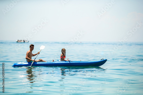 Sporty attractive family kayaking on sea together © travnikovstudio