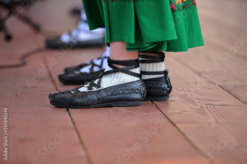 female legs in traditional leather shoes from tatra mountains region, caleld kierpce in polish language,  on floor