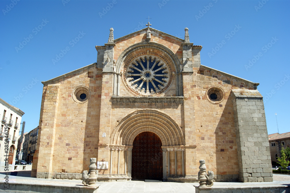 Spain, the historic city of Avila. Just outside the city walls.  The old church of St Peter the Apostle. A simple and elegant building. Rose windows, and grand entrance door.