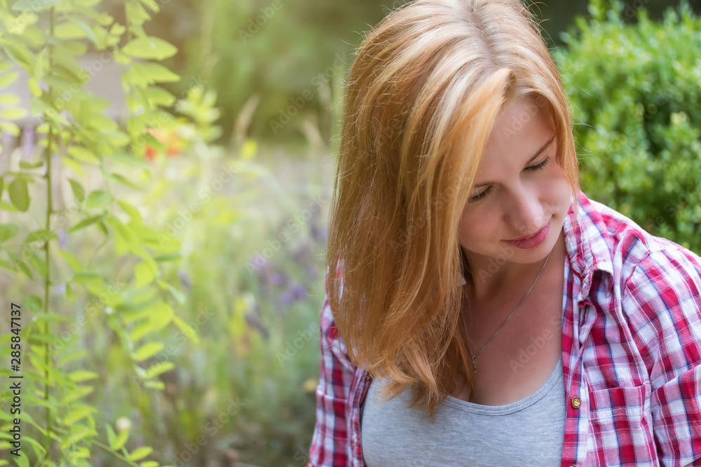 Portrait of pensive long haired attractive young woman looking at her body outdoors. There is enough space for the text in the photo. Portrait of pensive long haired attractive young woman looking at her body outdoors. There is enough space for the text in the photo.