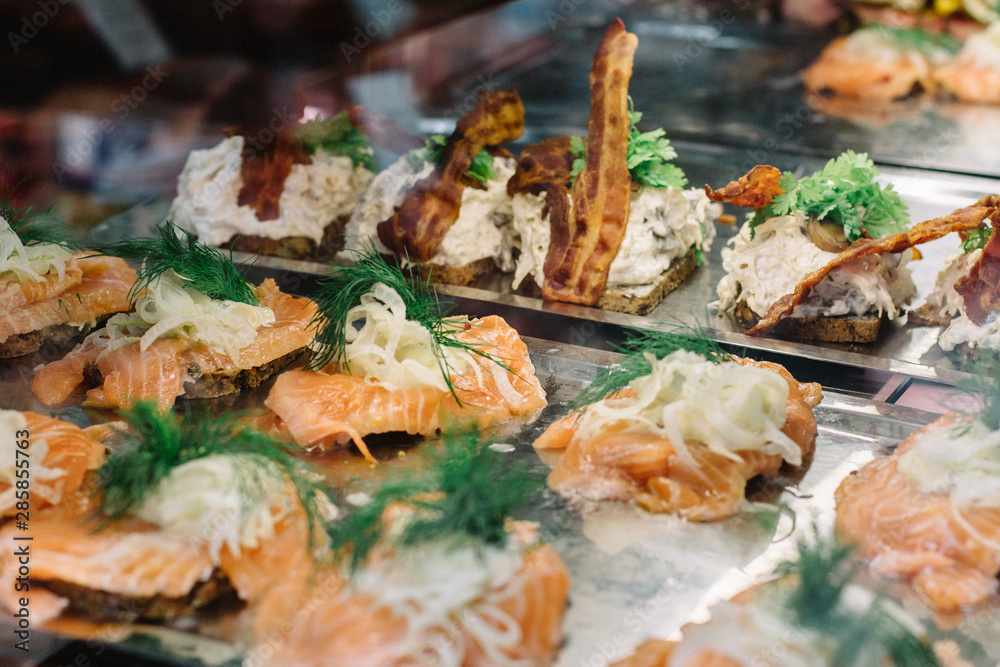 Selection of traditional open-faced Danish sandwiches,  smorrebrod, inside display case at a food market in Copenhagen, Denmark.