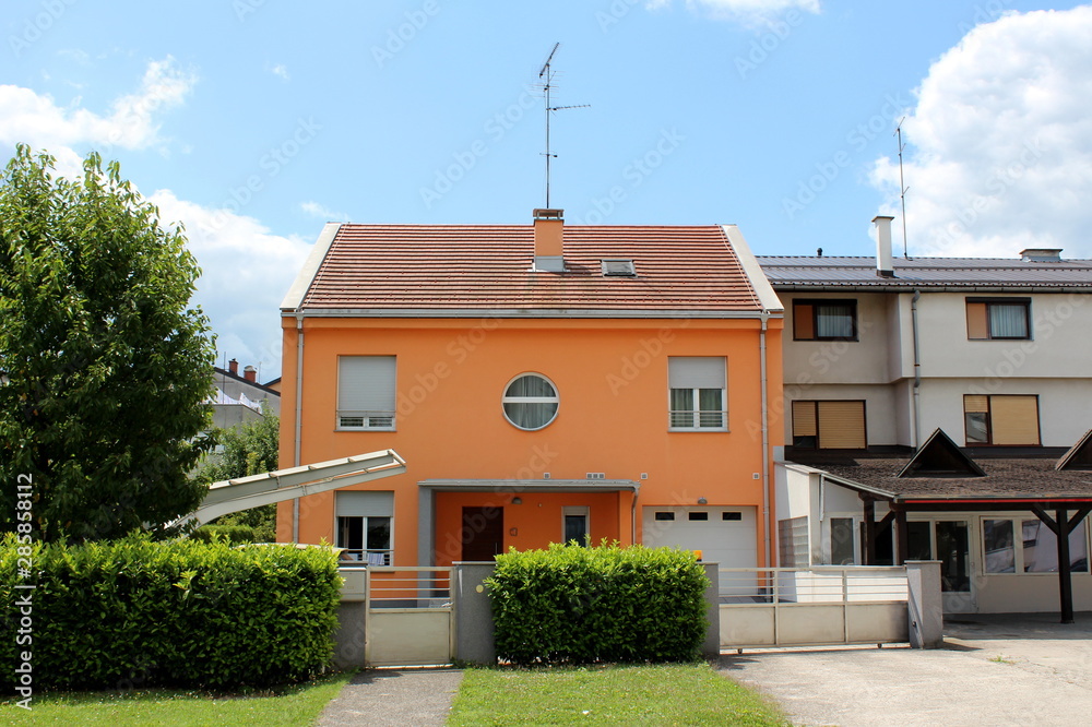 Φωτογραφία Attached new suburban family house with orange facade and new roof tiles surroun