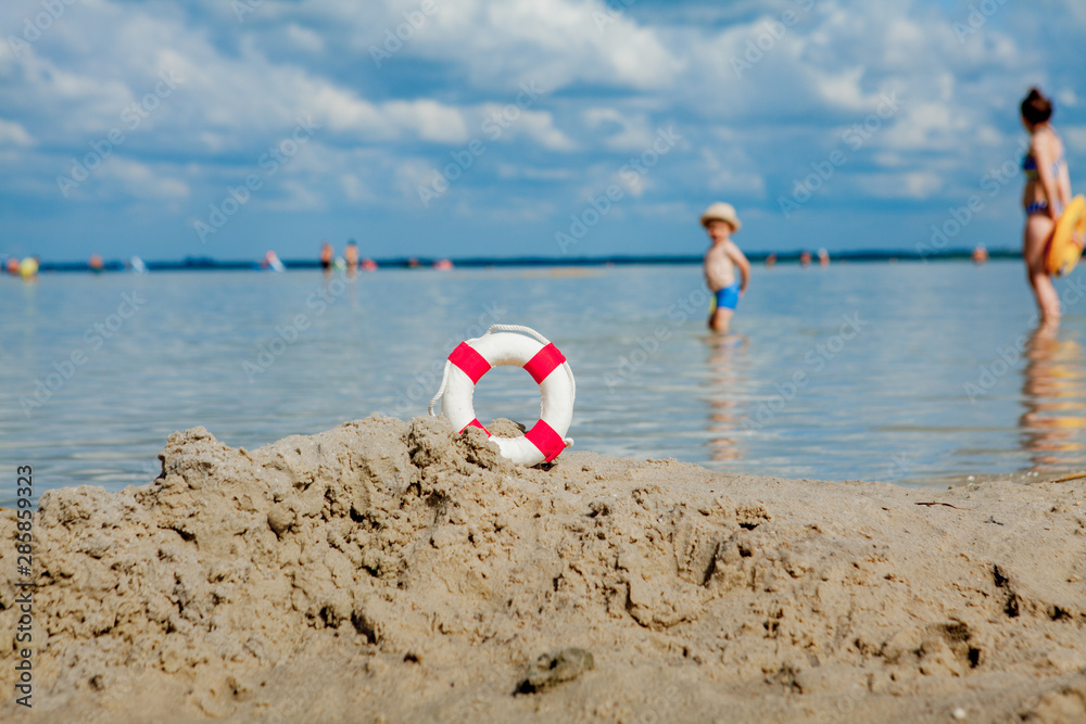 Obraz premium Close-up Of Lifebuoy on the beach on baby background. Safety on the water.