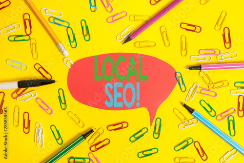 Word writing text Local Seo. Business photo showcasing incredibly effective way to market your near business online Flat lay above empty paper with copy space pencils and colored paper clips photo