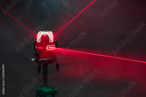 laser level tool red light beams in smoke photo