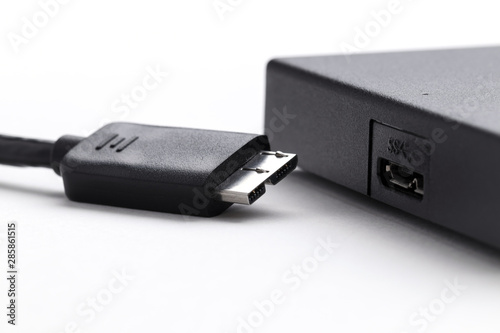 external hard drive and usb 3.0 cable on white background
