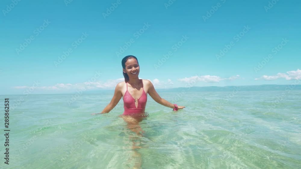 Charming asian woman enjoys bathing and splashing water in clear ocean. Charming asian woman enjoys bathing and splashing water in clear ocean.