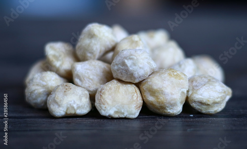 Candlenut or aleurites moluccana on wood background.